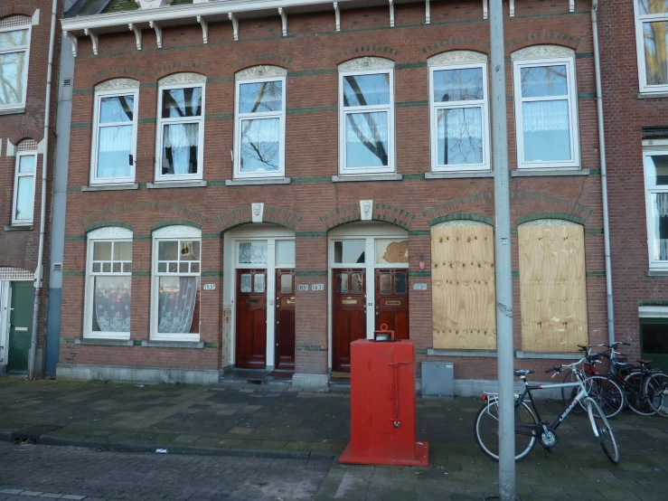 a tall brick building with two bicycles parked on the street