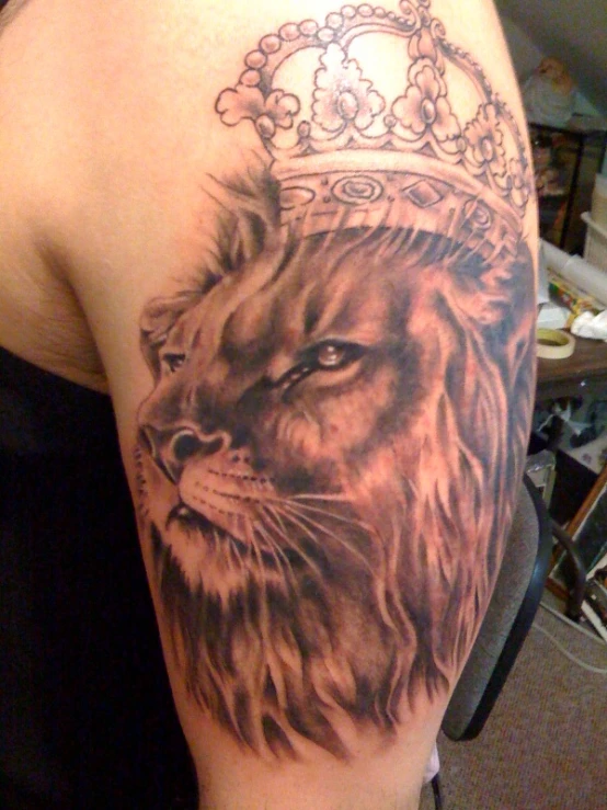 a woman with a lion and crown tattoo on her back