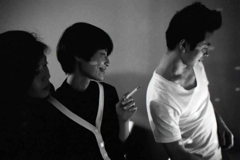 three women in black and white stand close together