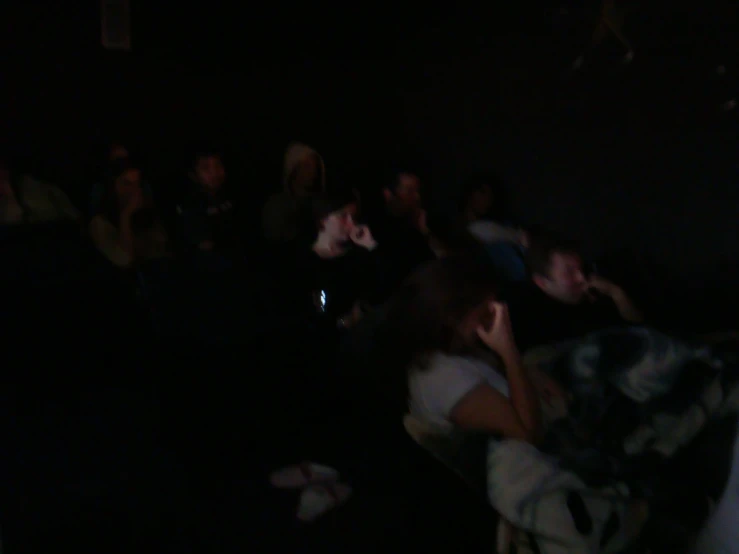 a blurry image of a crowd of people in a dark room