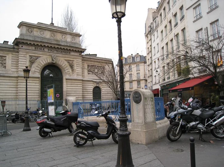 a sidewalk with mopeds parked in front of a building