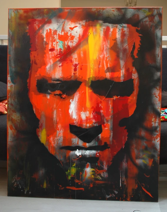 the large art piece features a male face with bright colored paint on it