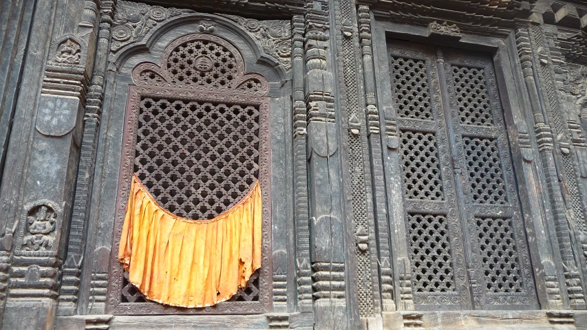 a close - up of an ornate wooden window with iron grates and wood shutters