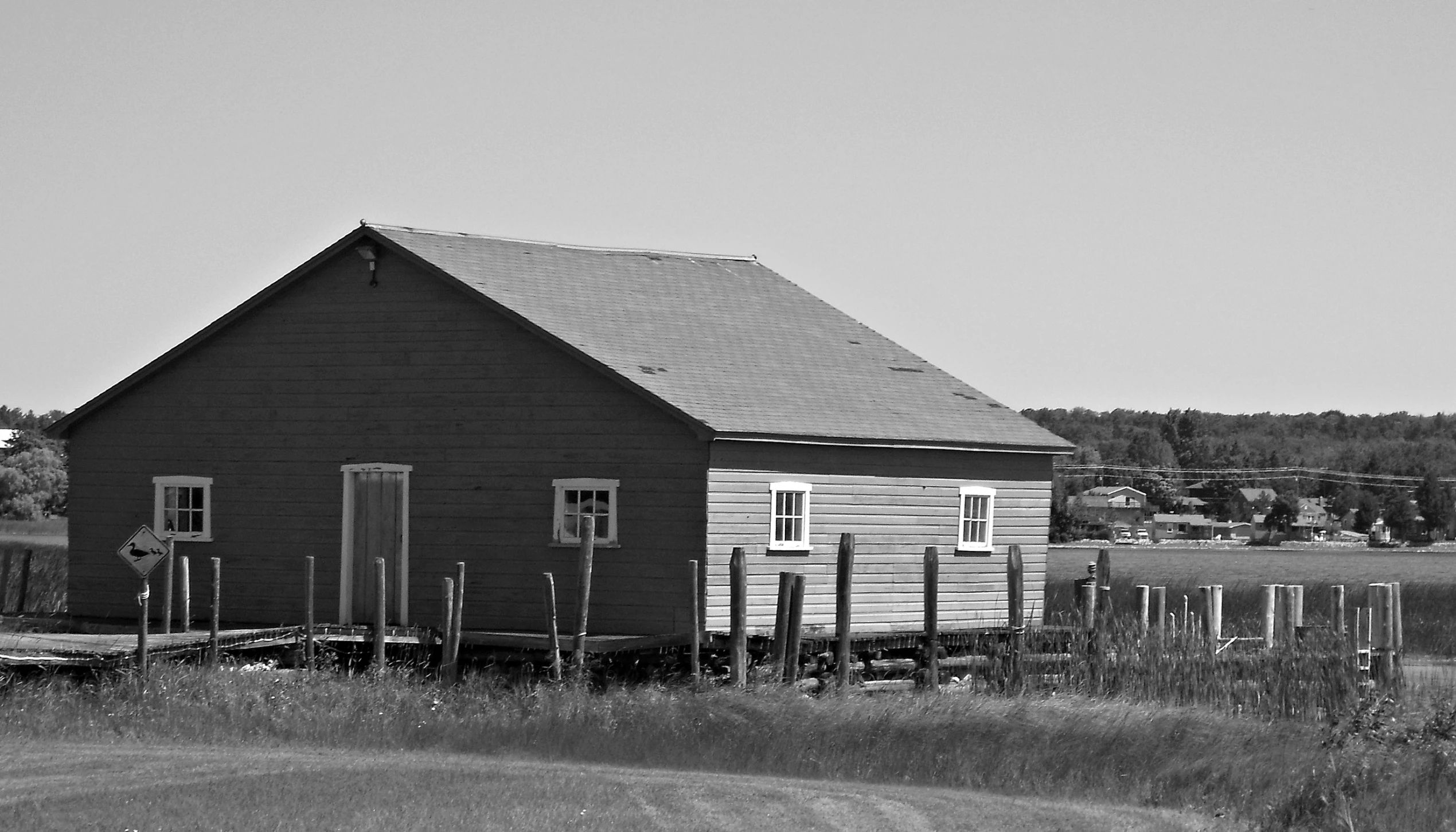 a black and white po of a house near a field