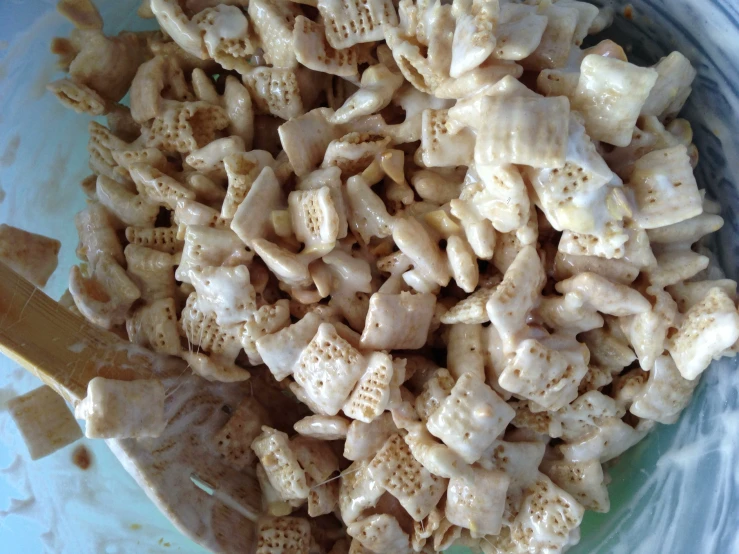 cereal, milk, and a wooden spoon in a blue bowl