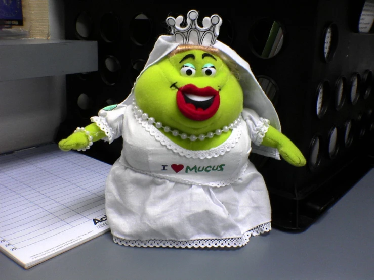 a large stuffed green creature with a tiara