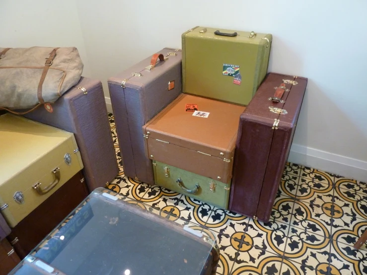 four stacks of suitcases sitting on a tiled floor