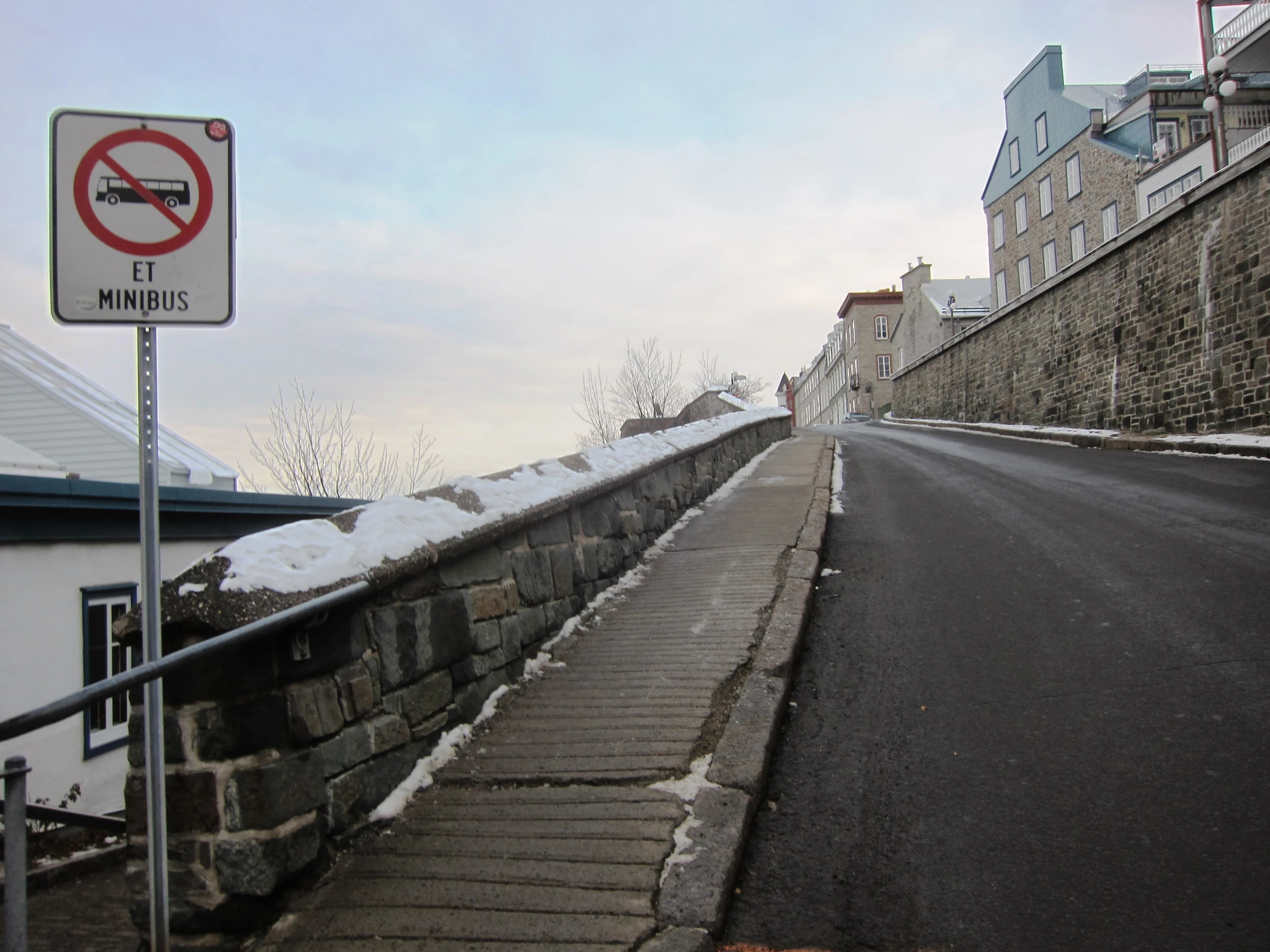 a road with snow covered ground and a no smoking sign on the side