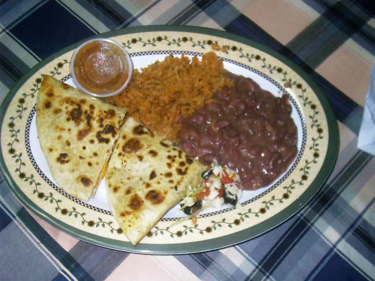 a close up of a plate of food with beans and tortillas