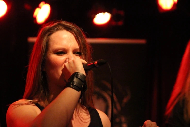 a beautiful young lady on stage holding a microphone