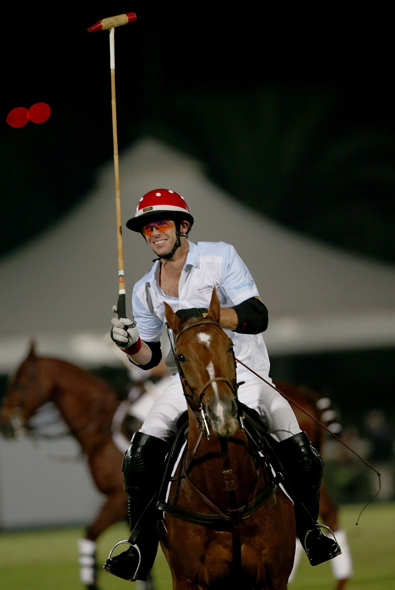 a polo player with his hat up riding a horse