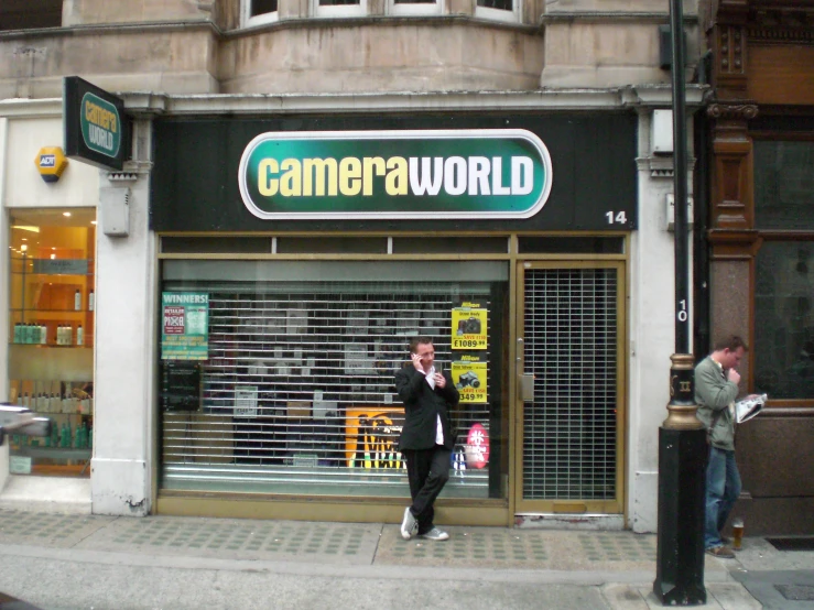 a man is standing in front of a cameraworld store