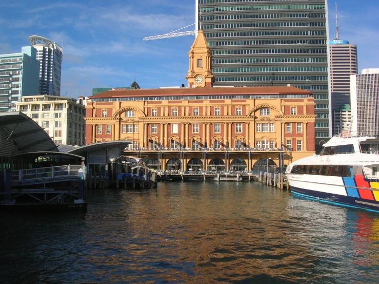 a big building sitting by the water with a clock tower