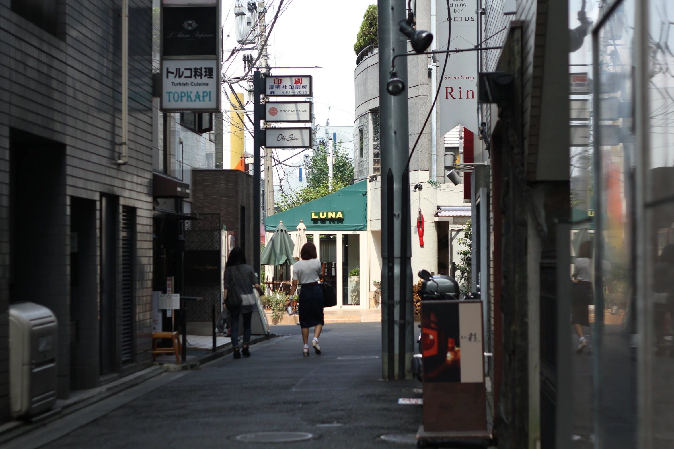 two people are walking down a street and one of them is on the phone