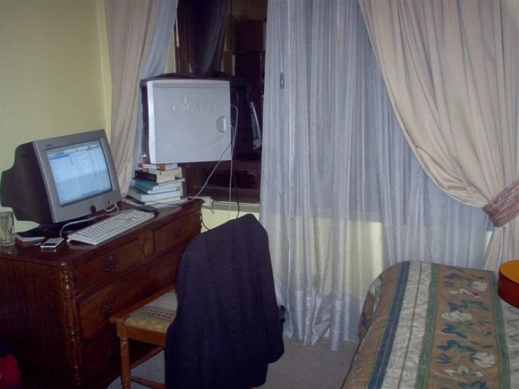 a television is turned on next to a desk and chair