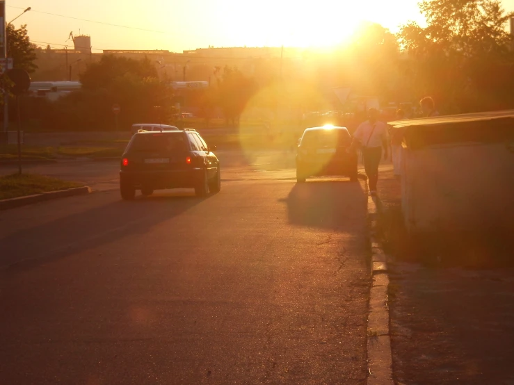 car and truck travelling on open street in the sunset