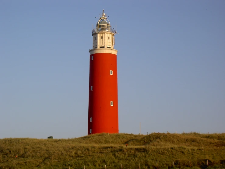 a tall light house on a hillside, on a clear day