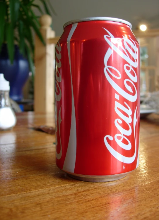 a red and white coca cola on the table