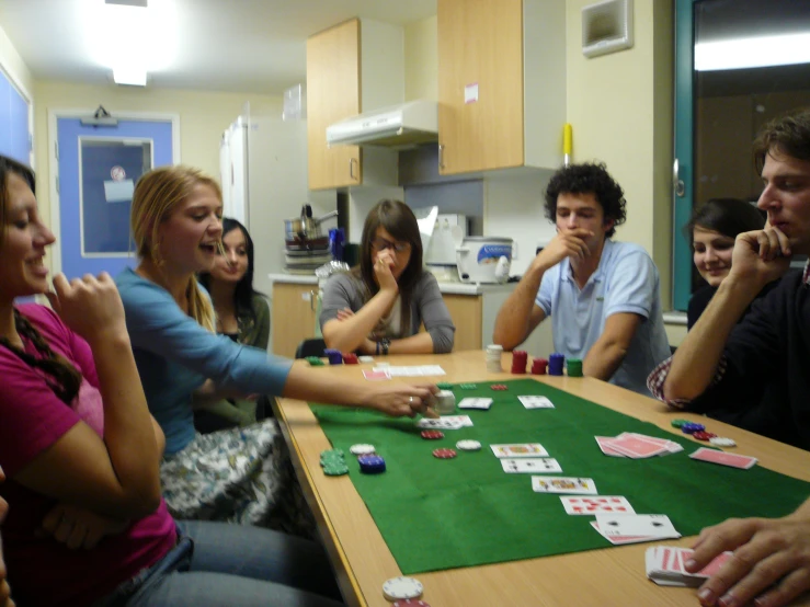 a group of people at a table playing cards