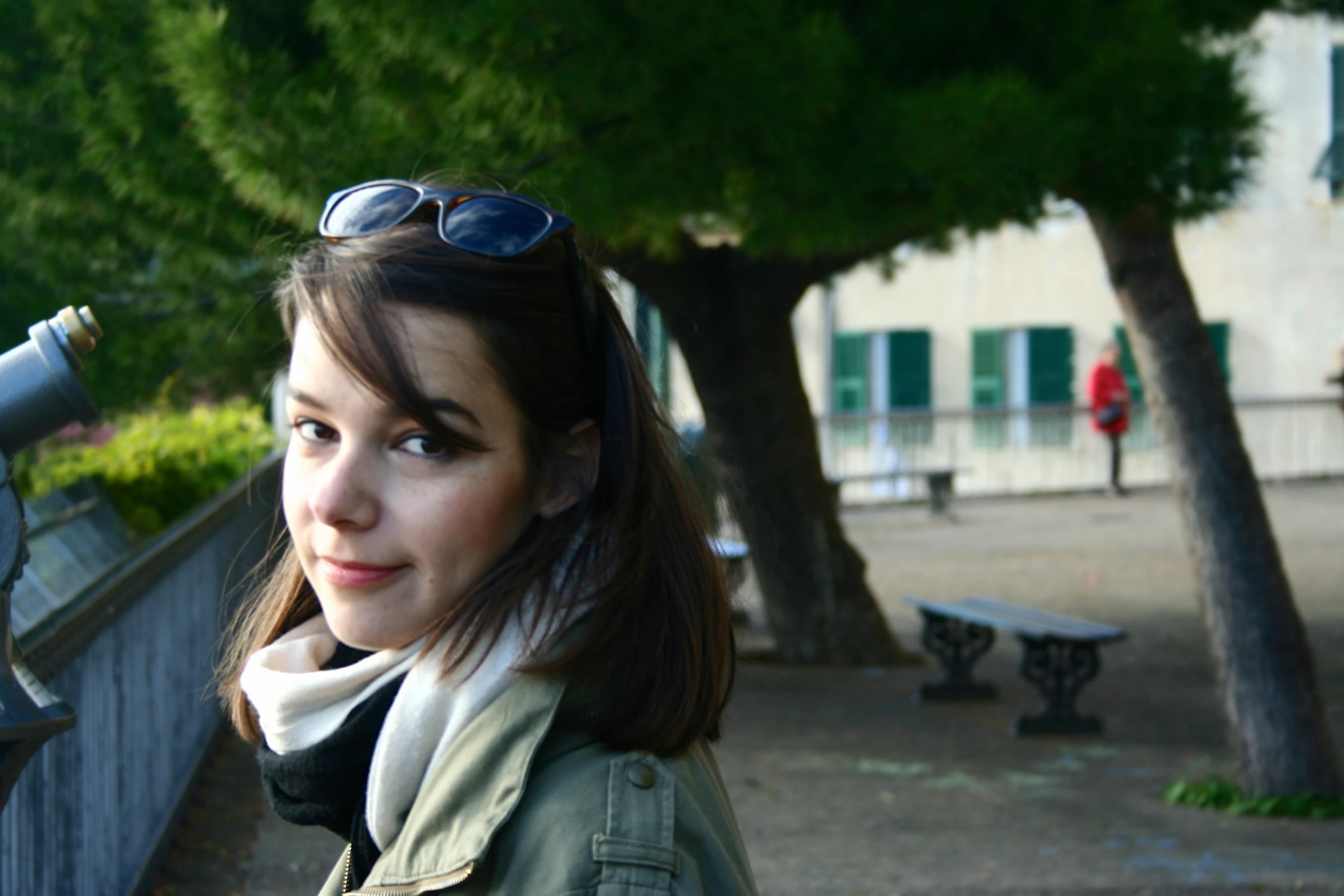 a woman is standing in front of a tree