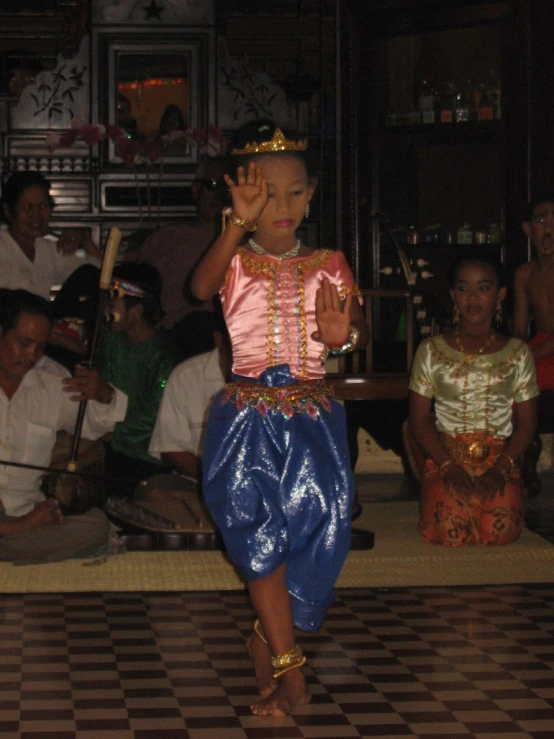  dressed in blue skirt and pink top with gold jewelry