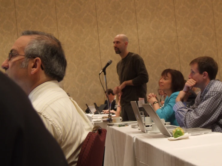 a group of people sitting around a table with microphones