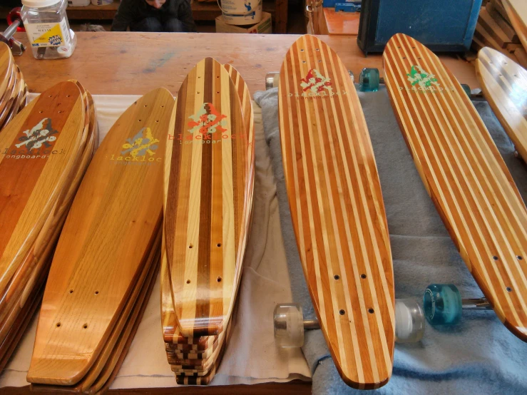 a variety of skateboards lined up and laying on the floor