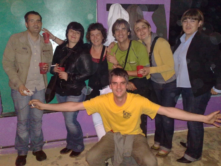 a group of people standing in front of a wall holding cell phones