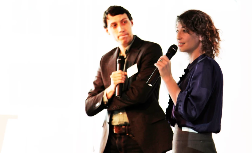 a man and woman are standing behind a microphone