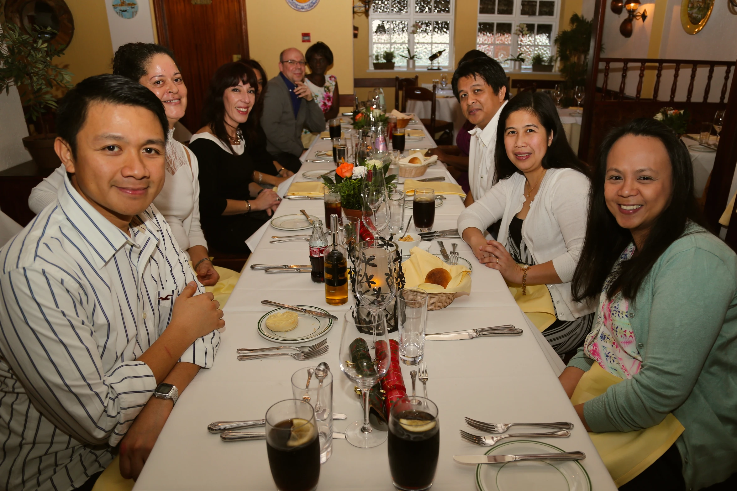 a group of people pose for a pograph around a table