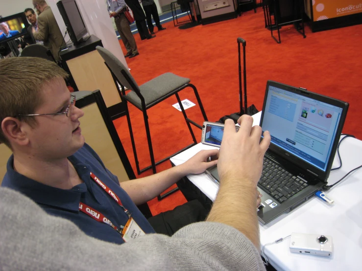 a man using a laptop computer while sitting at a desk