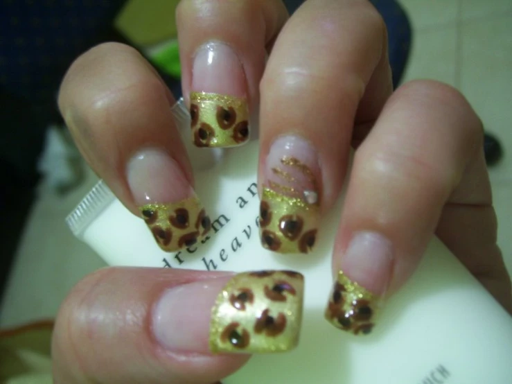 a person with a yellow and black design on their nail