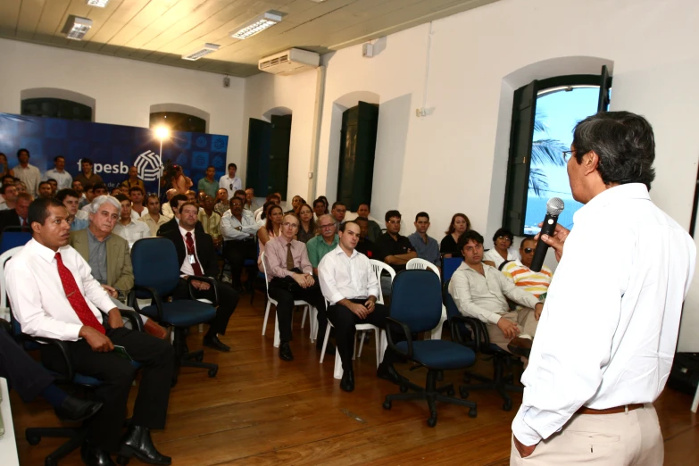 an audience of people are listening to speakers