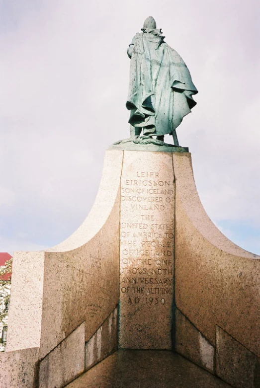 an older statue stands atop the edge of the wall
