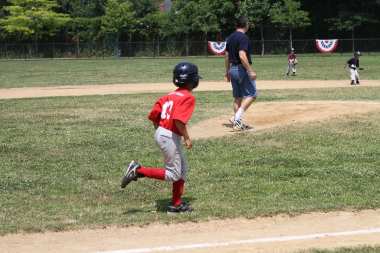 a young baseball player runs to first base