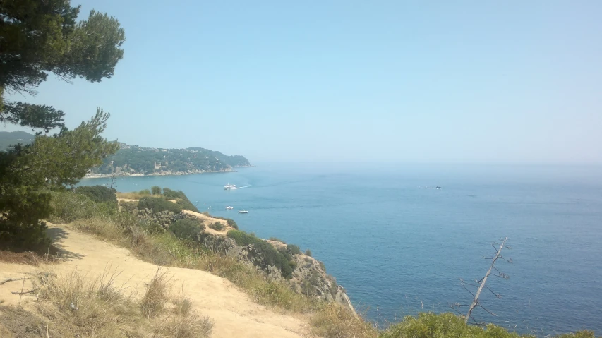 a dirt road along a cliff overlooking the water