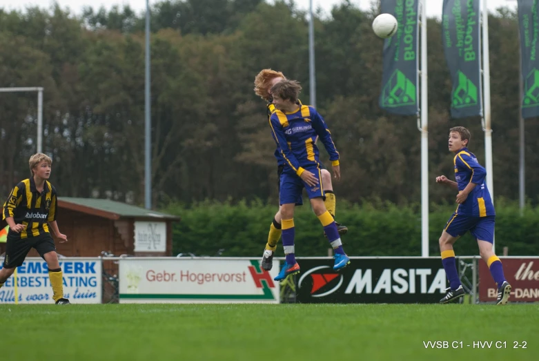 a woman kicking a soccer ball around with two other women watching