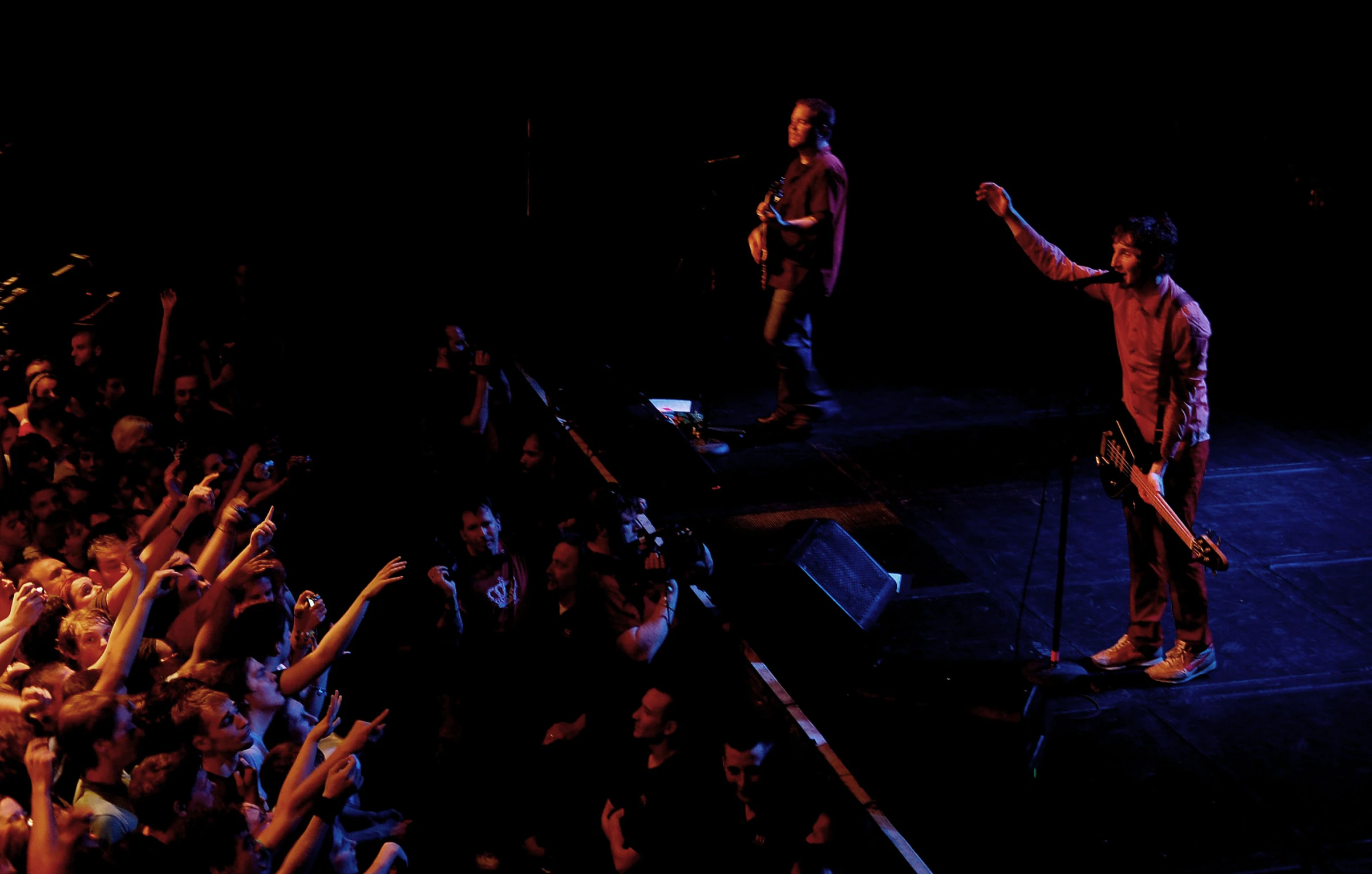 two male in concert singing to the audience