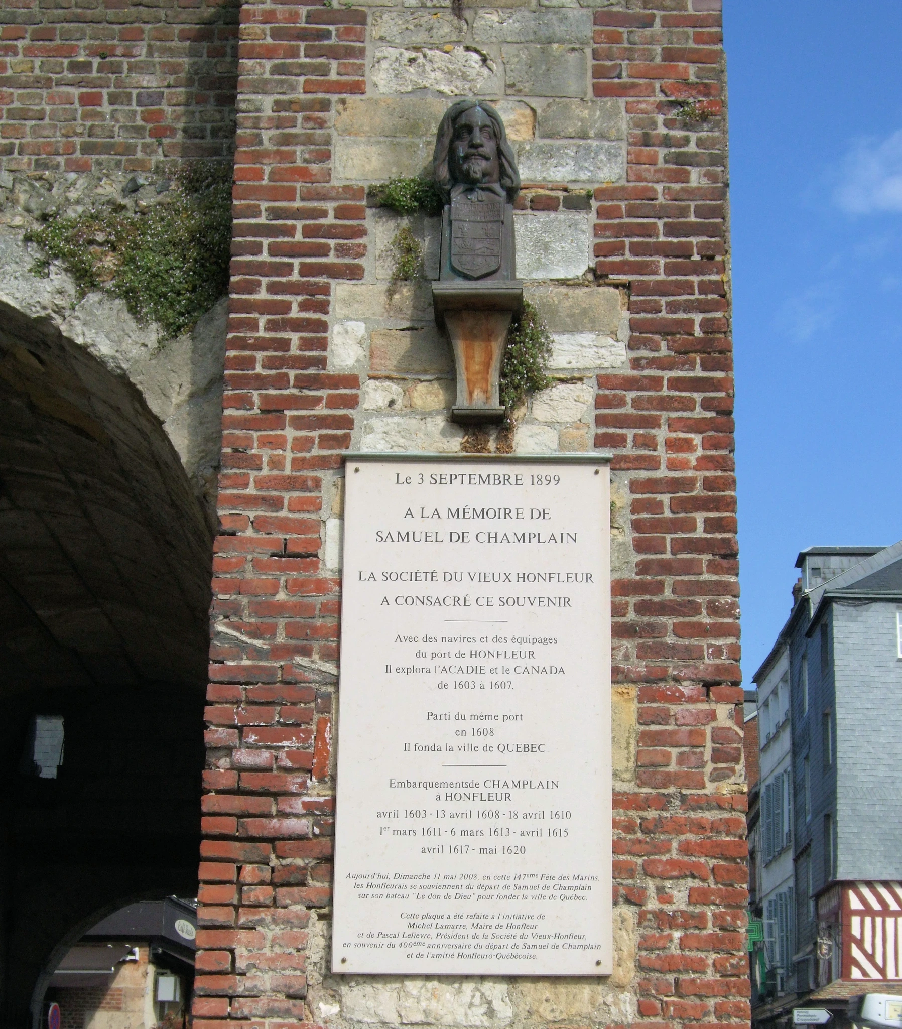 a plaque sits on the side of a brick building