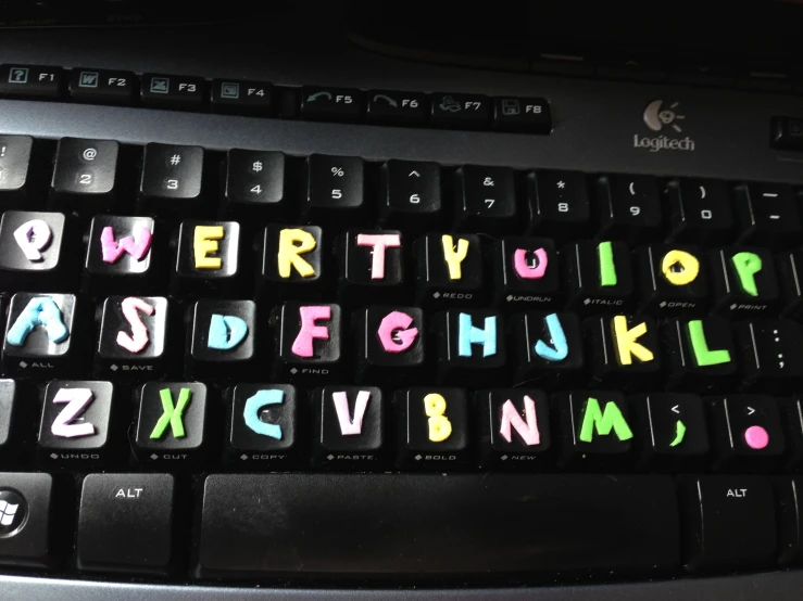 a black keyboard with a pink and blue computer key