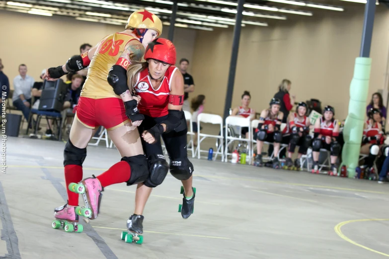 two people wearing helmets and skateboards in a crowded indoor area