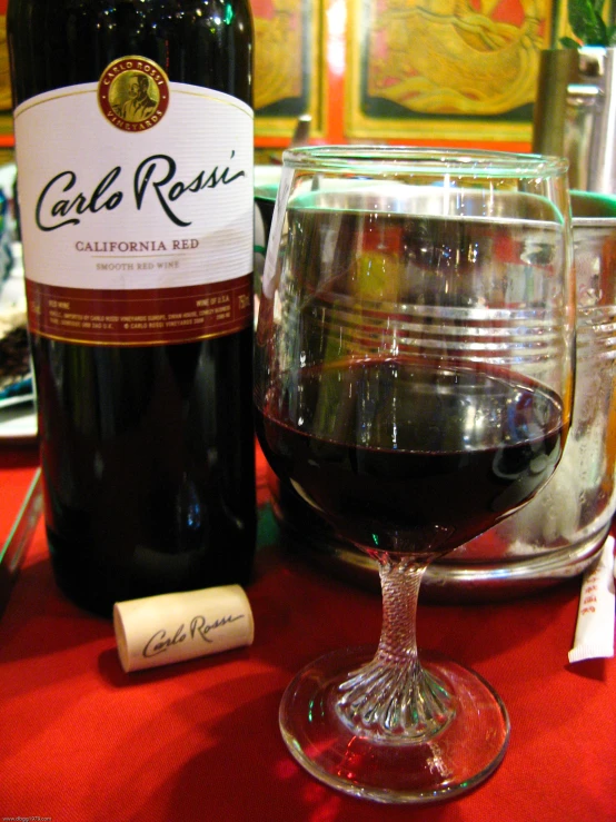 a bottle of wine sitting next to a glass on a table