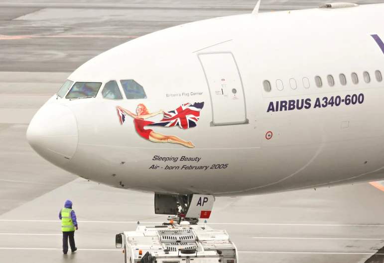 an airplane that is on the runway with people standing around it