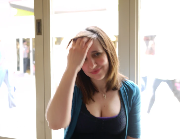 a woman in a blue top looking out a window