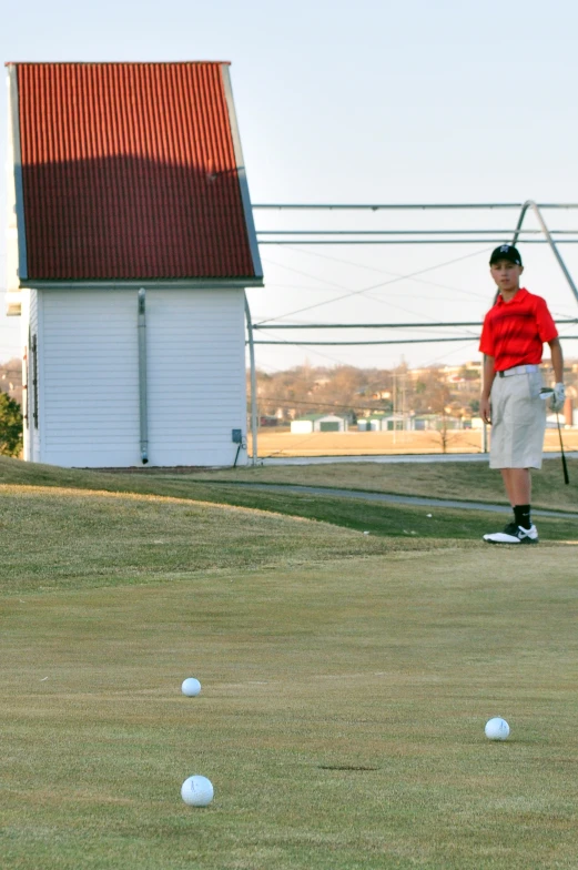 a man standing on top of a green golf ball field