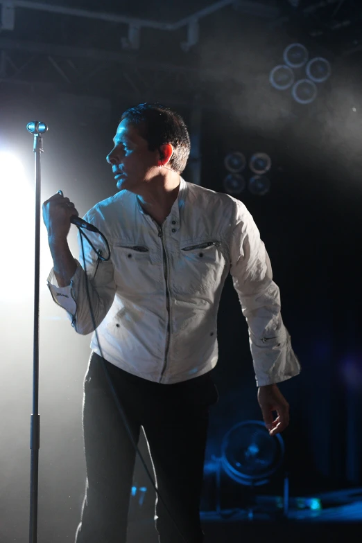 man holding microphone in his right hand at a stage