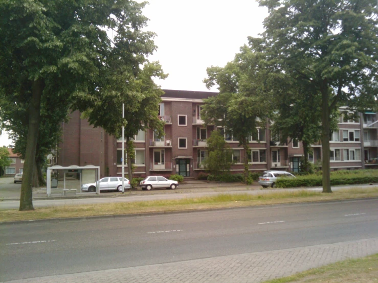 cars parked in front of a large apartment building