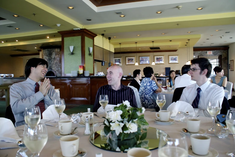 a group of people sitting around a table talking