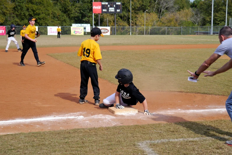 a young person standing at home plate trying to tag out another player