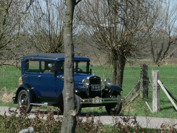 an old blue truck parked on a road